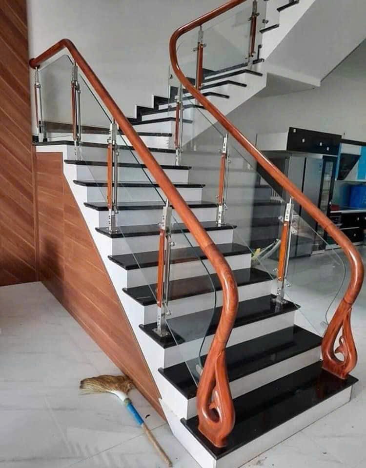 Cầu thang kính trụ inox tay vịn gỗ bo cong